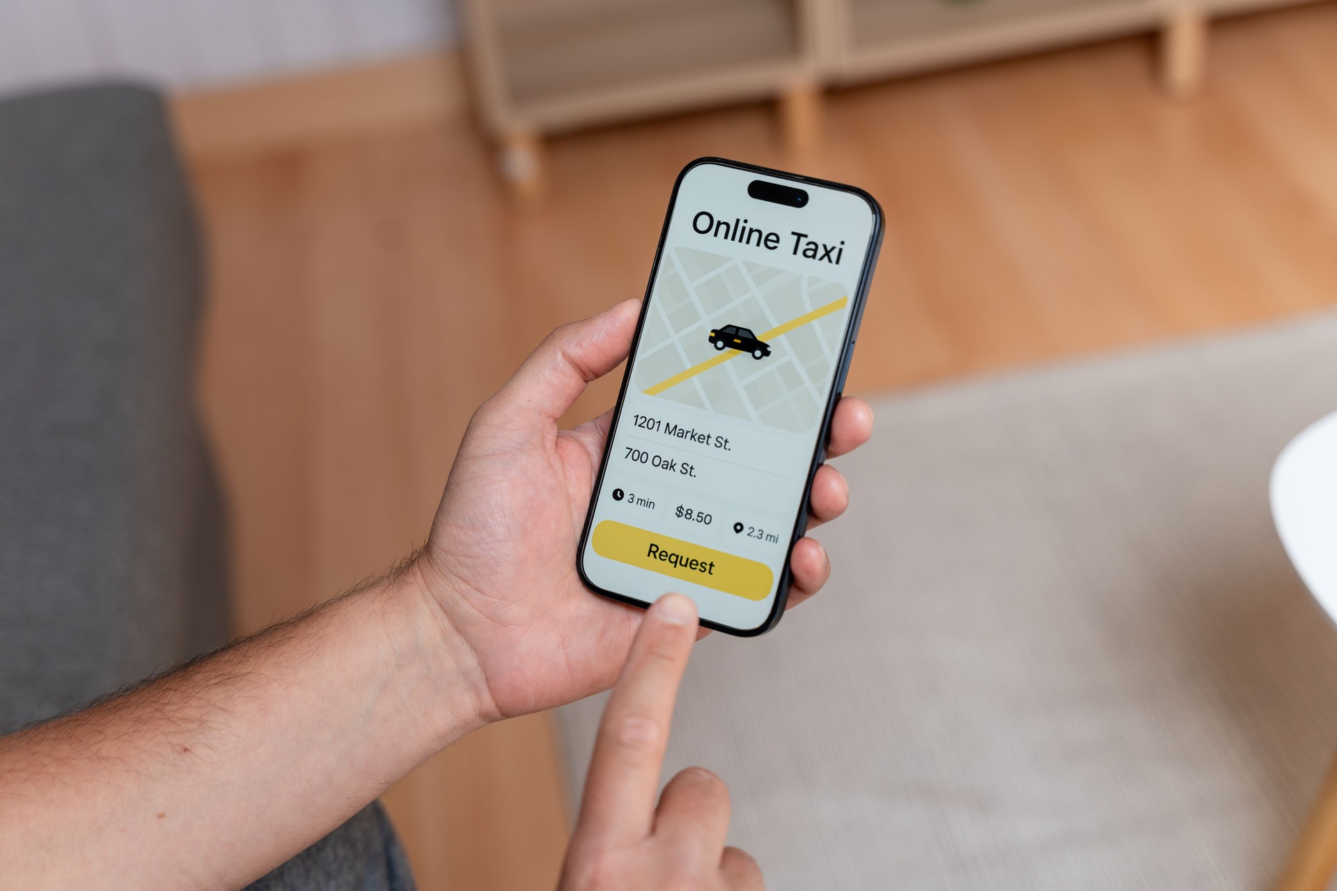 Customer ordering taxi using ride-hailing app on smartphone at home